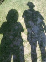 shadow of two people. One is wearing a cowboy hat.